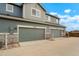 Two car garage featuring grey doors, stone accents and durable concrete driveway in this two story home at 16461 E 119Th Way # B, Commerce City, CO 80022