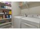 Functional laundry room with washer, dryer, shelving, and storage space at 16461 E 119Th Way # B, Commerce City, CO 80022