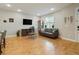 Comfortable living room featuring a leather sofa, wood floors, and a stylish display cabinet at 16461 E 119Th Way # B, Commerce City, CO 80022