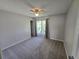 Cozy bedroom with large window, neutral tones, ceiling fan, and carpet flooring at 1265 S Biscay St, Aurora, CO 80017