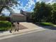 View of home with mature trees, long driveway and 2 car garage at 1265 S Biscay St, Aurora, CO 80017