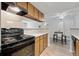 Kitchen with wooden cabinets, tile backsplash, modern appliances, and breakfast bar at 943 S Zeno Way # 102, Aurora, CO 80017
