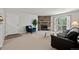 Cozy living room with a stone fireplace, soft carpet, balcony access, and comfortable seating arrangement at 943 S Zeno Way # 102, Aurora, CO 80017