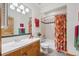 Bright bathroom features a floral shower curtain, tile floors, and wood vanity at 156 S Lookout Mountain Rd, Golden, CO 80401