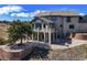 Beautiful home exterior with a large tree, stone landscaping, and a deck with arched windows, offering scenic views at 156 S Lookout Mountain Rd, Golden, CO 80401