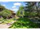Backyard featuring mature trees, a stone pathway, well-maintained greenery, and multilevel decks at 1560 Findlay Way, Boulder, CO 80305