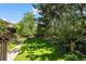 Lush backyard showcasing a stone pathway, birdbath, greenery, and mature trees for a serene outdoor oasis at 1560 Findlay Way, Boulder, CO 80305