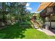 Spacious backyard with a tiered deck, lush lawn, mature trees and beautiful landscaping at 1560 Findlay Way, Boulder, CO 80305