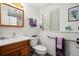 Bright bathroom with wood vanity, toilet, window, decorative towels, and accessible grab bar for safety at 1560 Findlay Way, Boulder, CO 80305