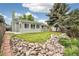 Charming backyard with mature trees, rock gardens, and beautiful lawn at 9431 W Jewell Pl, Lakewood, CO 80227