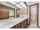 Bathroom featuring a long vanity, double sinks, and a large mirror, all well-lit at 9431 W Jewell Pl, Lakewood, CO 80227