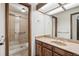 Bathroom with tiled shower, vanity, and framed mirror at 9431 W Jewell Pl, Lakewood, CO 80227