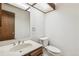 Well-lit half bathroom with marble countertops, classic fixtures, and a framed mirror at 9431 W Jewell Pl, Lakewood, CO 80227