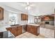 Cozy kitchen featuring wood cabinets, white countertops, and an open view of the sunken living room at 9431 W Jewell Pl, Lakewood, CO 80227