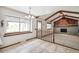 Bright living room boasts beamed ceilings, large windows, and a brick fireplace at 9431 W Jewell Pl, Lakewood, CO 80227