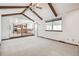 Inviting living room with beamed ceilings and a view into the kitchen, creating an open and airy space at 9431 W Jewell Pl, Lakewood, CO 80227