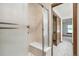 Tiled shower with built-in seating and a glass door, adjacent to a spacious bedroom at 9431 W Jewell Pl, Lakewood, CO 80227
