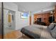 Bright bedroom with hardwood floors, brick wall, mounted tv, and closet at 3225 Blake St # 8, Denver, CO 80205