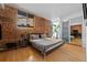 Bedroom with exposed brick wall, hardwood floors, and closet at 3225 Blake St # 8, Denver, CO 80205