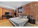 Bedroom with exposed brick wall, hardwood floors, and desk setup at 3225 Blake St # 8, Denver, CO 80205