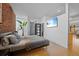 Bedroom with hardwood floors, closet, mounted TV, brick wall, and large window at 3225 Blake St # 8, Denver, CO 80205