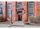 Exterior shot of building entrance featuring brick facade, gate, and well-manicured landscaping at 3225 Blake St # 8, Denver, CO 80205