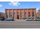 Exterior shot of building with brick facade, tall windows, and street parking at 3225 Blake St # 8, Denver, CO 80205