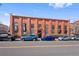 Exterior shot of building with brick facade, tall windows, and street parking at 3225 Blake St # 8, Denver, CO 80205