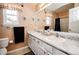 Bathroom featuring a shower, toilet, double sink vanity with a large mirror, and a window at 57 N 45Th Ave, Brighton, CO 80601