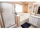 Clean bathroom featuring a shower, tub, large window, and a vanity with a sink and storage at 57 N 45Th Ave, Brighton, CO 80601