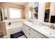 Bright bathroom showcasing a tub, shower, double sink vanity with great storage, and large window at 57 N 45Th Ave, Brighton, CO 80601