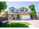 Charming two-story home with a stone facade, lush lawn, and inviting front porch seating at 57 N 45Th Ave, Brighton, CO 80601