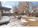 Backyard with partially snow-covered grass, patio, and outdoor seating at 3695 Quail St, Wheat Ridge, CO 80033