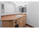 Bathroom vanity with tile countertop, storage, mirror and sink at 3695 Quail St, Wheat Ridge, CO 80033