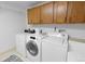 Laundry room with wooden cabinets, washer, and dryer at 3695 Quail St, Wheat Ridge, CO 80033