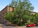 Brick apartment building with mature trees, lush landscaping, and well-maintained grounds at 2500 S York St # 204, Denver, CO 80210
