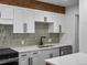 Updated kitchen with white cabinetry, modern backsplash, and stainless steel appliances at 2500 S York St # 204, Denver, CO 80210