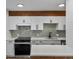 Updated kitchen with white cabinets, modern backsplash, and stainless steel appliances at 2500 S York St # 204, Denver, CO 80210