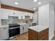 Renovated kitchen featuring white cabinets, butcher block island, and stainless steel appliances at 2500 S York St # 204, Denver, CO 80210