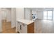 Open floor plan with kitchen island, modern fireplace, and balcony at 2500 S York St # 204, Denver, CO 80210