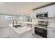 Modern kitchen with white shaker cabinets, quartz countertops, and stainless steel appliances at 4735 W Bayaud Ave, Denver, CO 80219