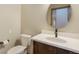 Modern bathroom featuring a round mirror, clean white countertops, and a stylish dark wood vanity at 19165 Golden Arrow Cir, Monument, CO 80132