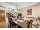 Dining room open to the living room with hardwood floors, modern lighting, and a view of the fireplace at 19165 Golden Arrow Cir, Monument, CO 80132