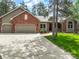 Charming brick and tan home with a spacious driveway and manicured front yard surrounded by mature trees at 19165 Golden Arrow Cir, Monument, CO 80132