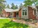 Brick front exterior with a covered porch and well-manicured lawn at 19165 Golden Arrow Cir, Monument, CO 80132