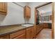 Cozy kitchen featuring wood cabinets, stone countertops, and view into adjacent kitchen space at 19165 Golden Arrow Cir, Monument, CO 80132