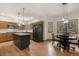 Spacious kitchen with wood cabinets, a black island, stainless steel appliances, and hardwood flooring at 19165 Golden Arrow Cir, Monument, CO 80132