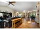 Open-concept living room with hardwood floors, a brick fireplace, and seamless flow to the dining area at 19165 Golden Arrow Cir, Monument, CO 80132