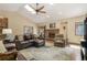 Comfortable living room with vaulted ceiling, ceiling fan, fireplace, and view of the backyard through the window at 19165 Golden Arrow Cir, Monument, CO 80132