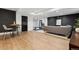 Finished basement with bar and seating area, dark brick accent wall and light wood floors at 815 E Westglow Ln, Greenwood Village, CO 80121